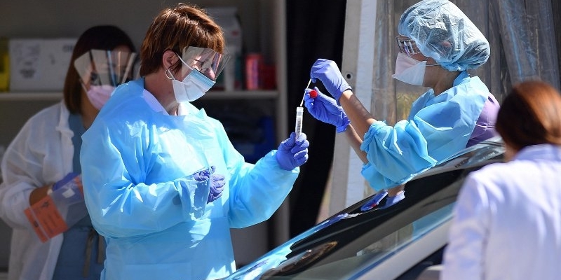 Medical workers at Kaiser Permanente French Campus test a patient for the novel coronavirus, COVID-19, at a drive-thru testing facility in San Francisco, California on March 12, 2020. - Between 70 to 150 million people in the United States could eventually be infected with the novel coronavirus, according to a projection shared with Congress, a lawmaker said March 12, 2020. (Photo by Josh Edelson / AFP) (Photo by JOSH EDELSON/AFP via Getty Images)